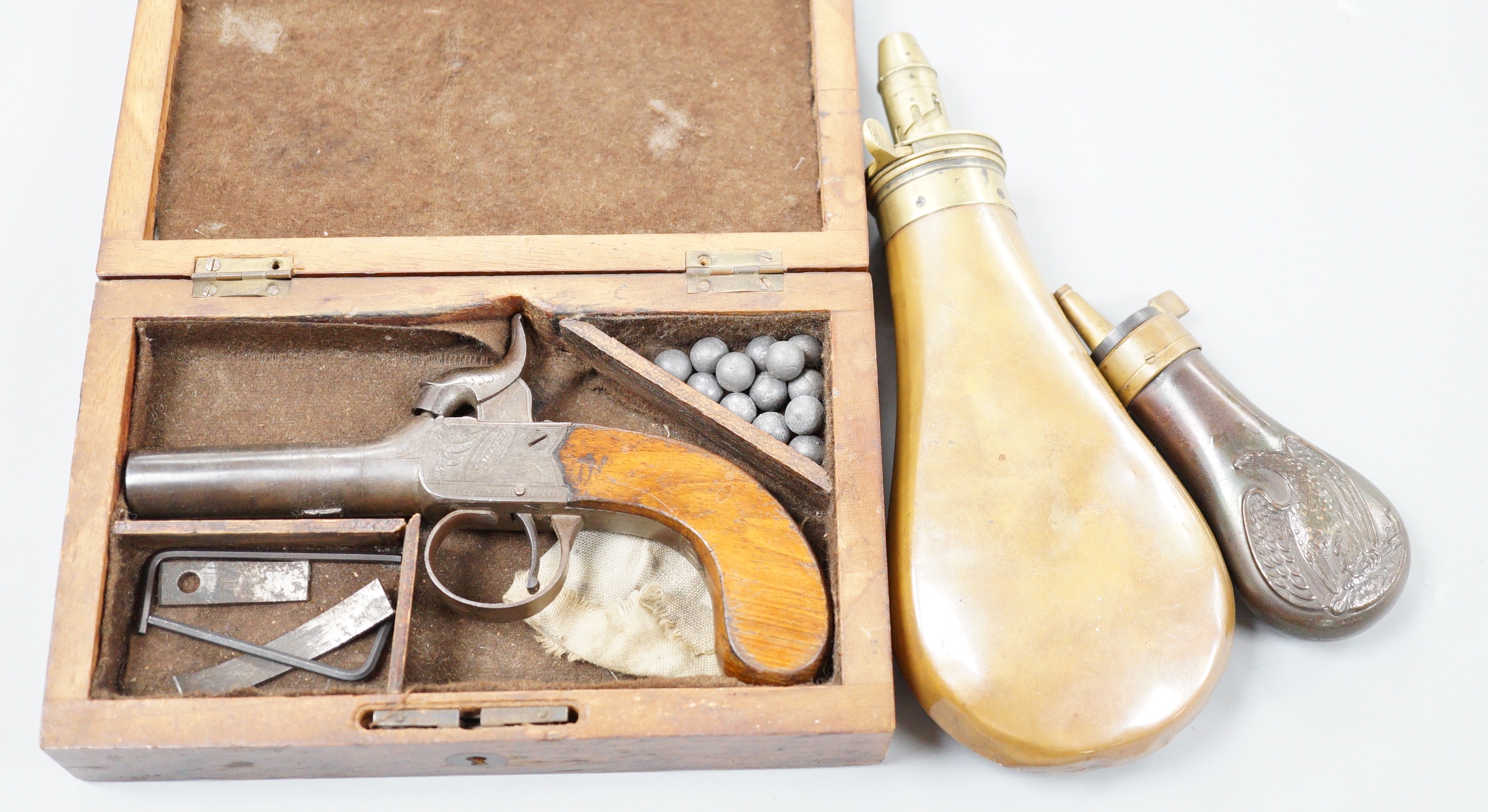 A cased early 19th century percussion pocket pistol by Smith, London and 2 shot flasks
